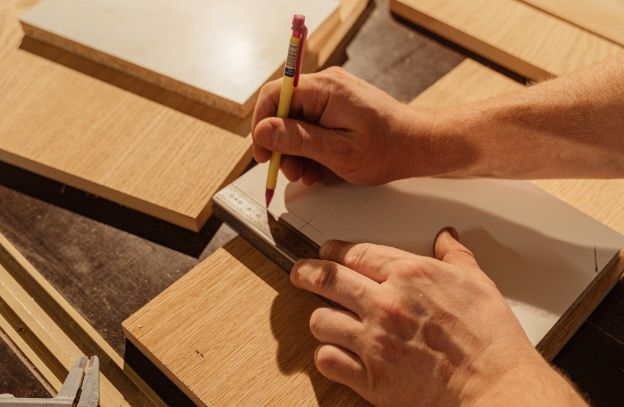 hands measuring out a wood template