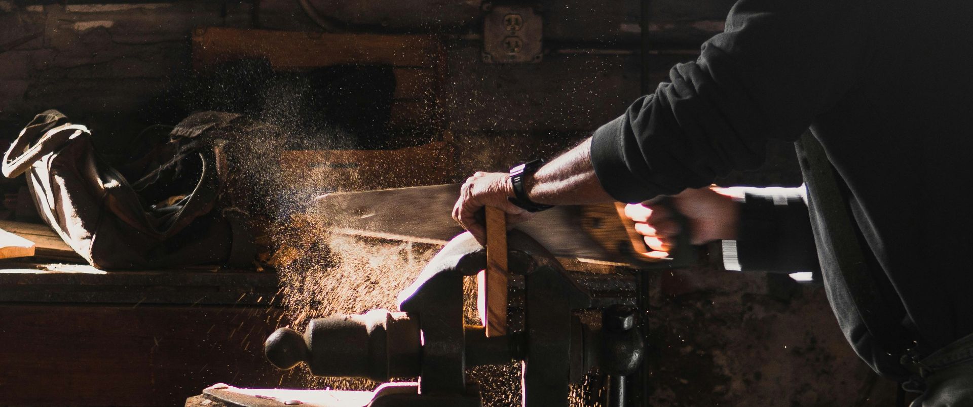 carpenter using hand saw in a clamp