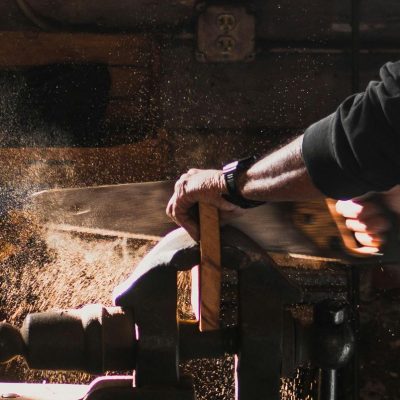 carpenter using hand saw in a clamp