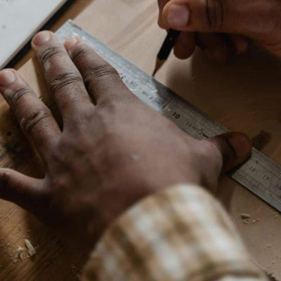 hands with a ruler measuring out on a board